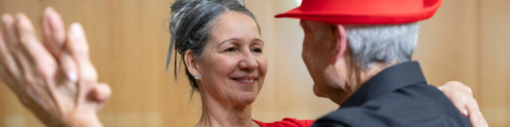 close up senior woman dancing holding hands with her partner in